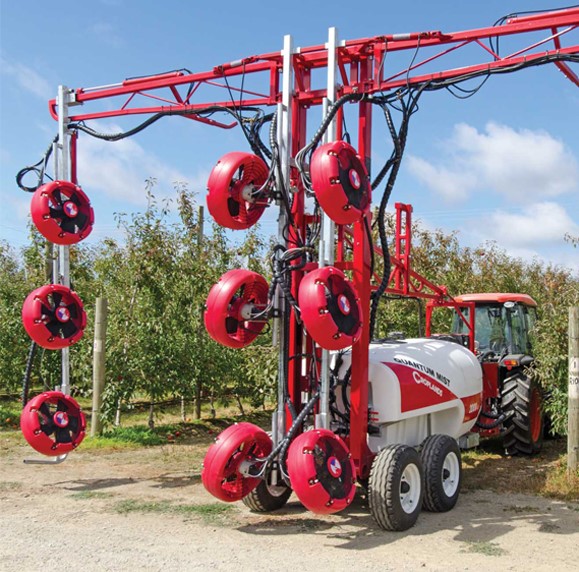 Red tractor towing spray tank and equipment