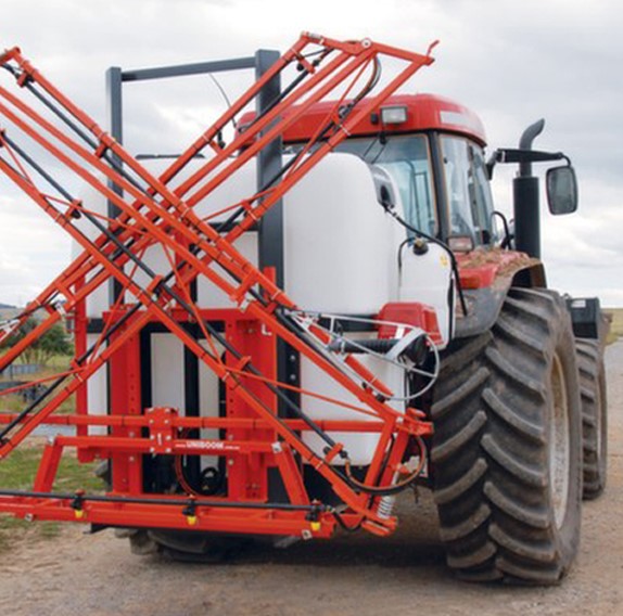 Red tractor with spray tank and folded boom